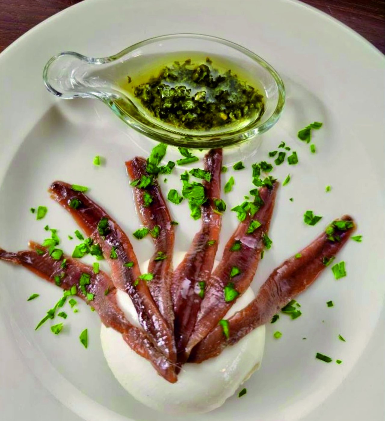Antipasto di acciughe con burrata servito nel ristorante trattoria a Como